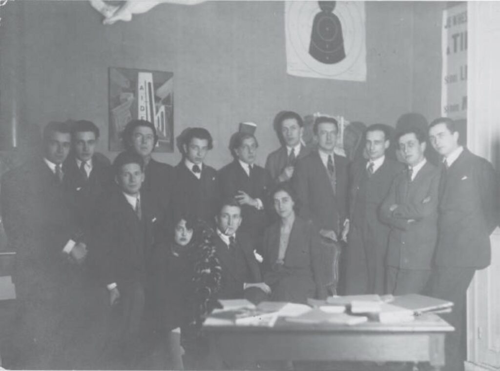 Man Ray, la Centrale surréaliste, décembre 1924, photographie. De gauche à droite (de haut en bas) : Baron, Queneau, Naville, Breton, Boiffard, De Chirico, Vitrac, Éluard, Soupault, Desnos, Aragon, Simone Kahn, Morise, Mick Soupault. © Man Ray 2015 Trust / Adagp, Paris, 2025